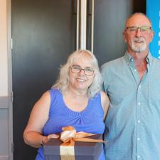 One female retiree and her male guest stand to pose for photo