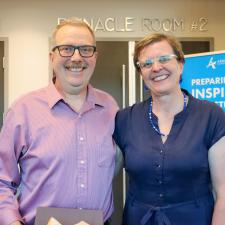 Male retiree stands and smiles with his female guest