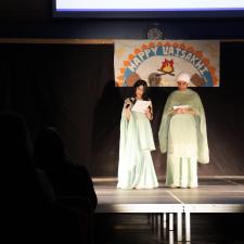 Two secondary students standing on stage as they MC the event